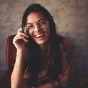 Girl Smiling While Holding Her Glasses